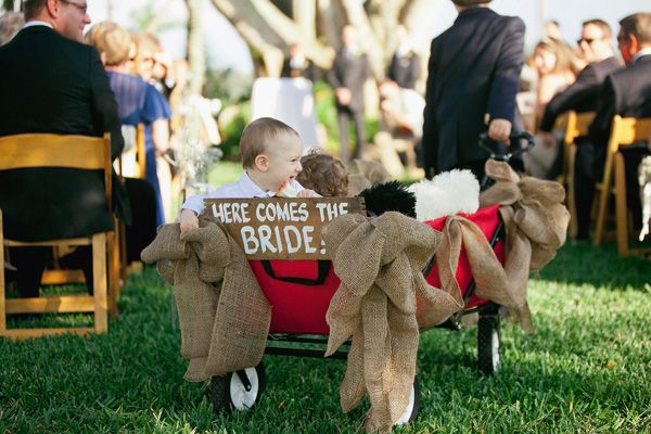 flower girl pulling baby in wagon