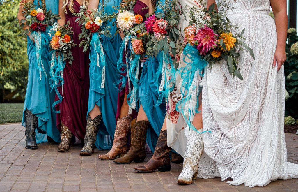Bride and Bridesmaids standing together showing their Cowboy boots