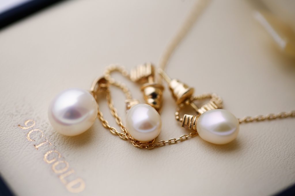 Flatlay image of beautiful pearls and 9 carat gold chain