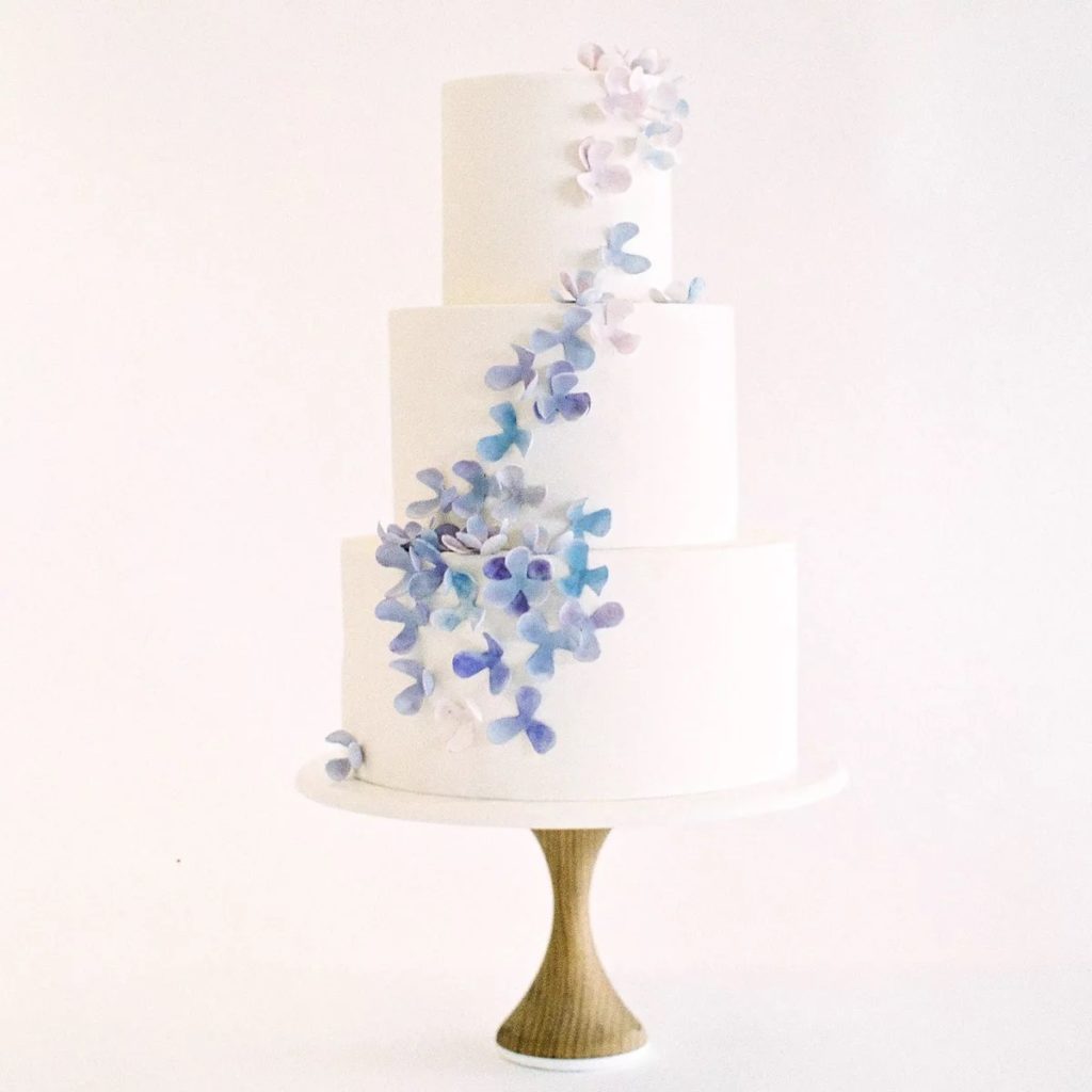 white fondant wedding cake with a gradient design of blue and violet watercolor