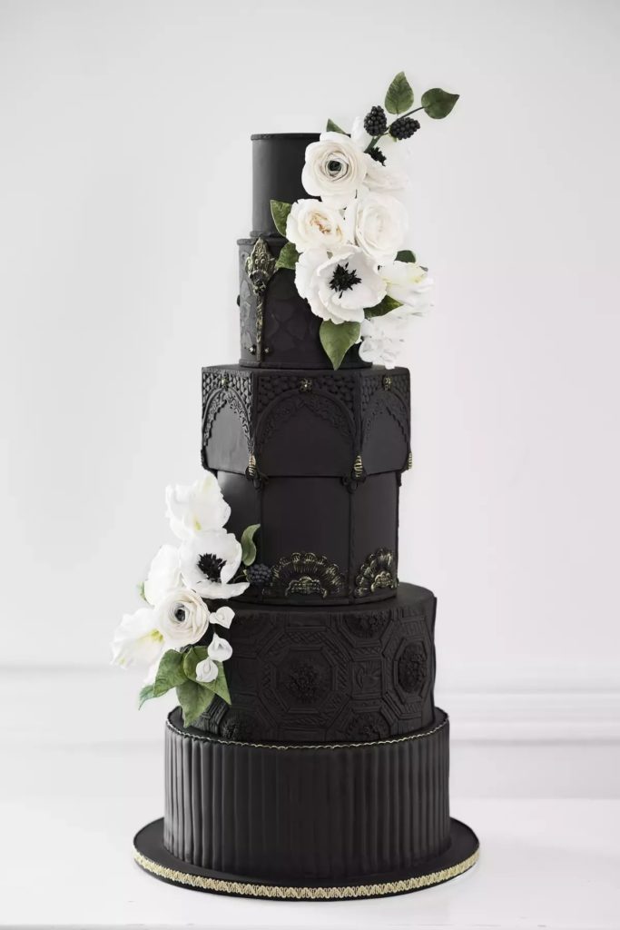 Modern art inspired black wedding cake with large white flowers