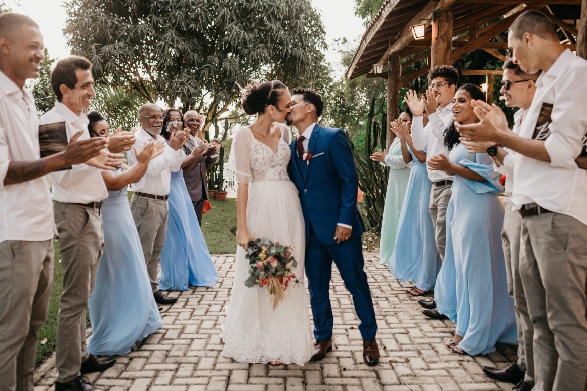 Bride and Groom kissing surrounded by bridesmaids and groomsmen