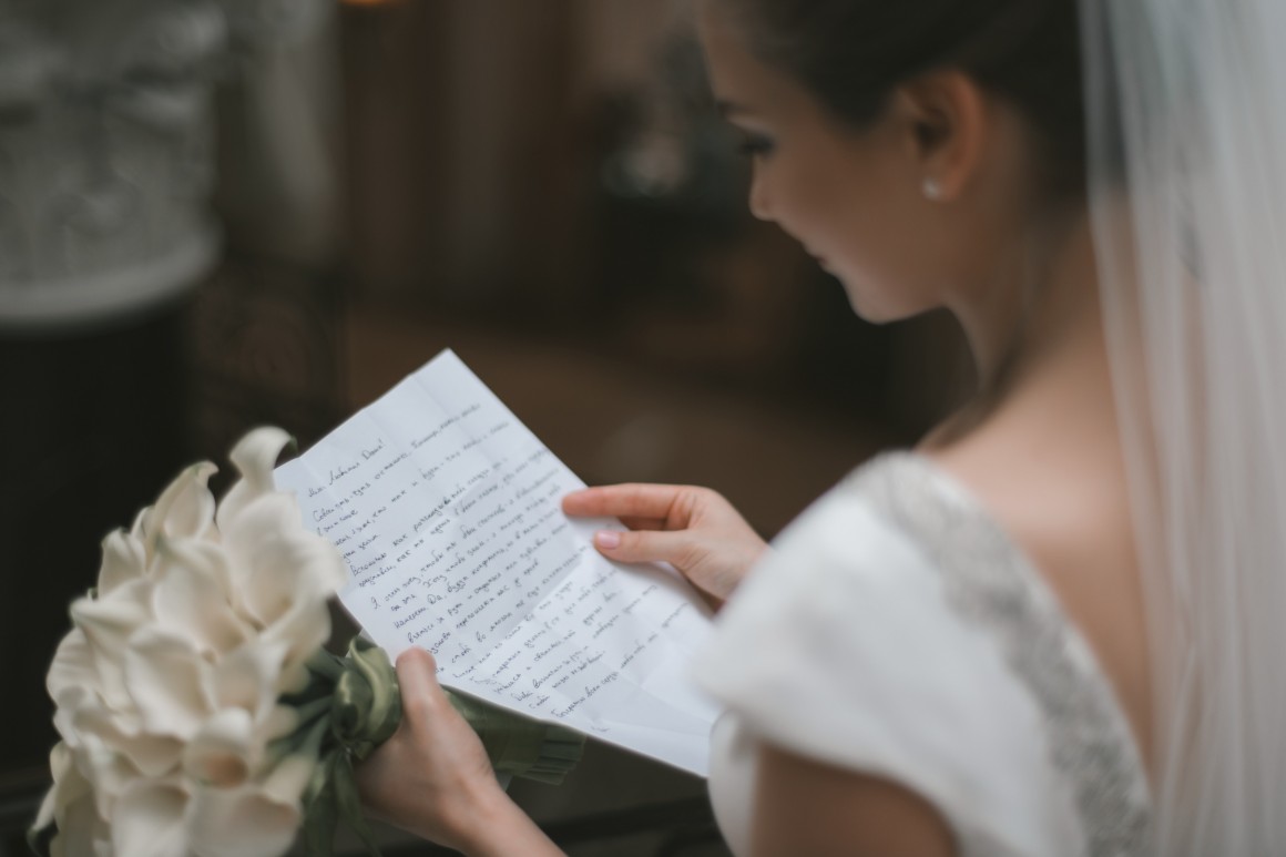 Bride reading wedding vows with bridal bouquet in hand