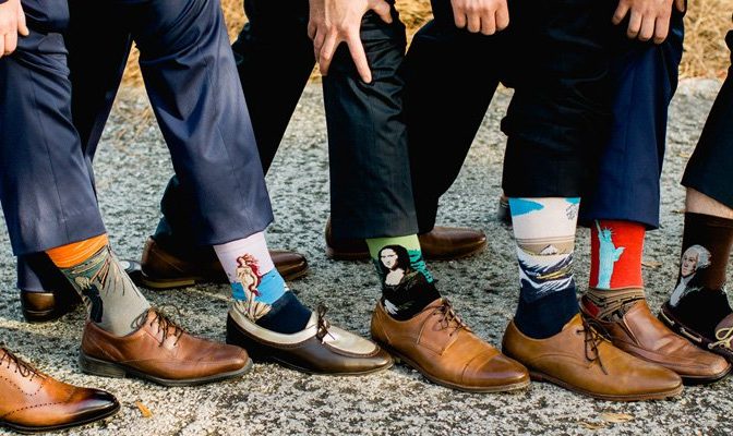 Set of groomsmen wearing socks with different famous paintings