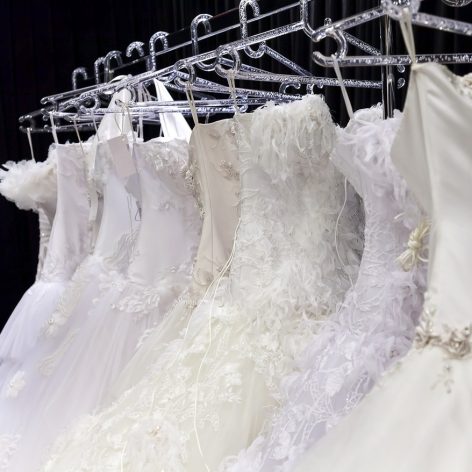 Various wedding dresses on coat rack