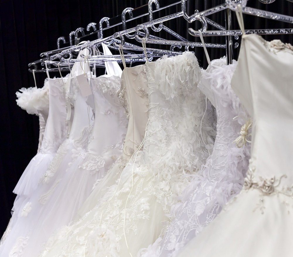 Various wedding dresses on coat rack