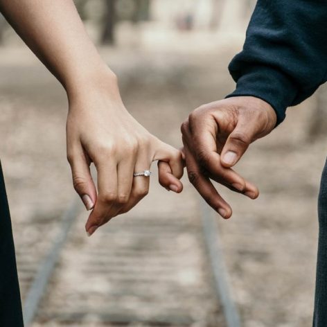 Man and women with pinky fingers linked