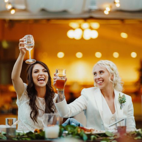Smiling wedding guests lifting glasses during toast