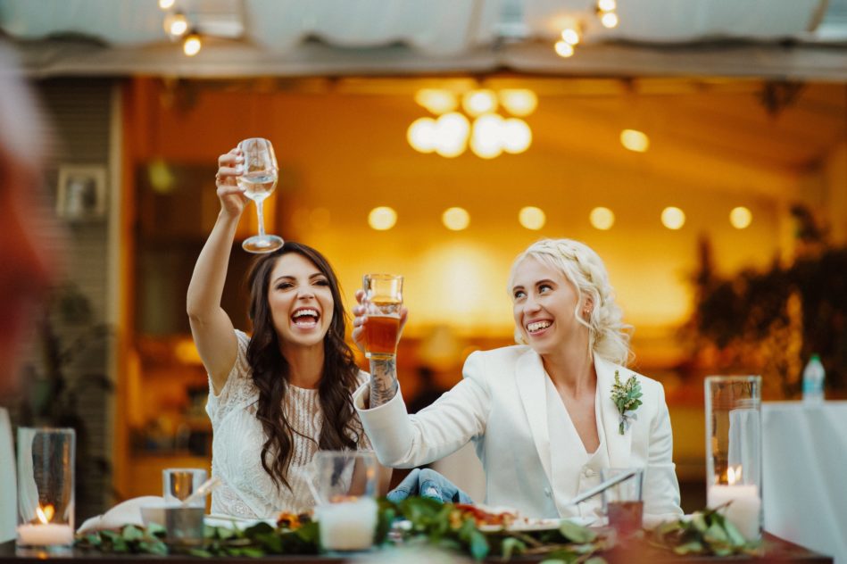 Smiling wedding guests lifting glasses during toast