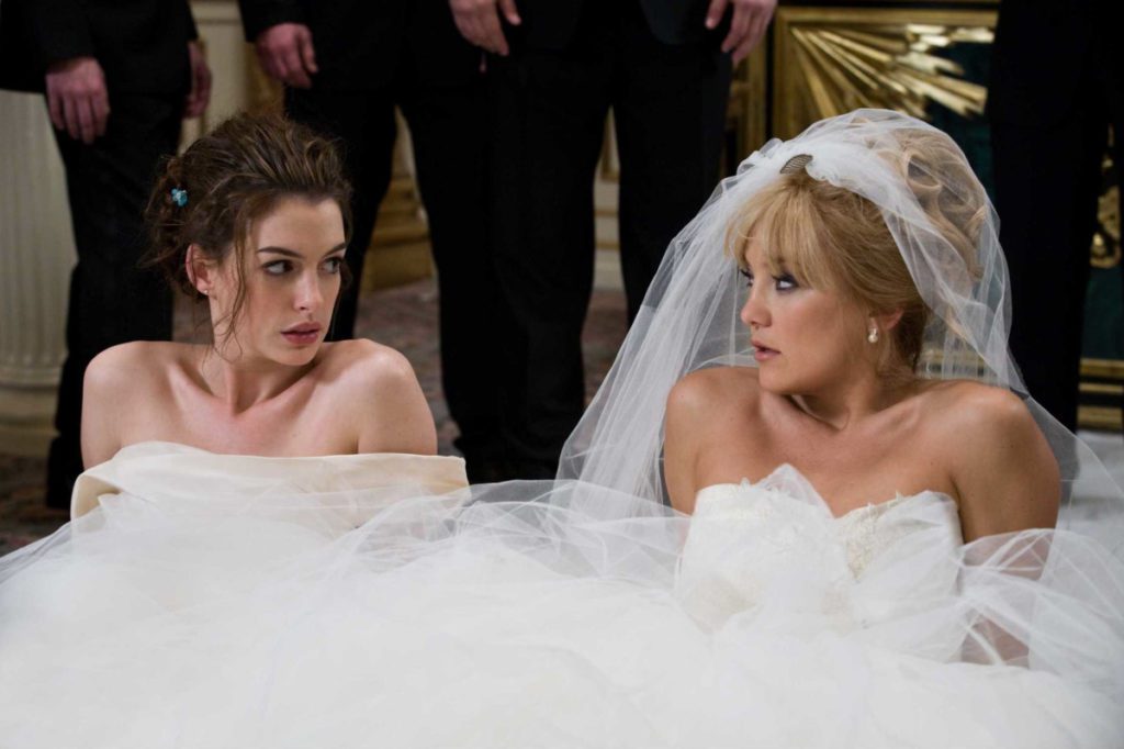 Kate Hudson and Anne Hathaway sitting on floor in wedding dresses during Bride Wars movie