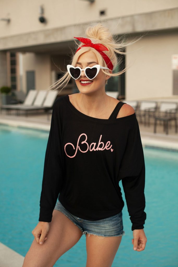 Pretty blonde wearing Black Babe sweatshirt next to pool