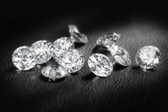 Cluster of loose diamonds for jewelry on black leather