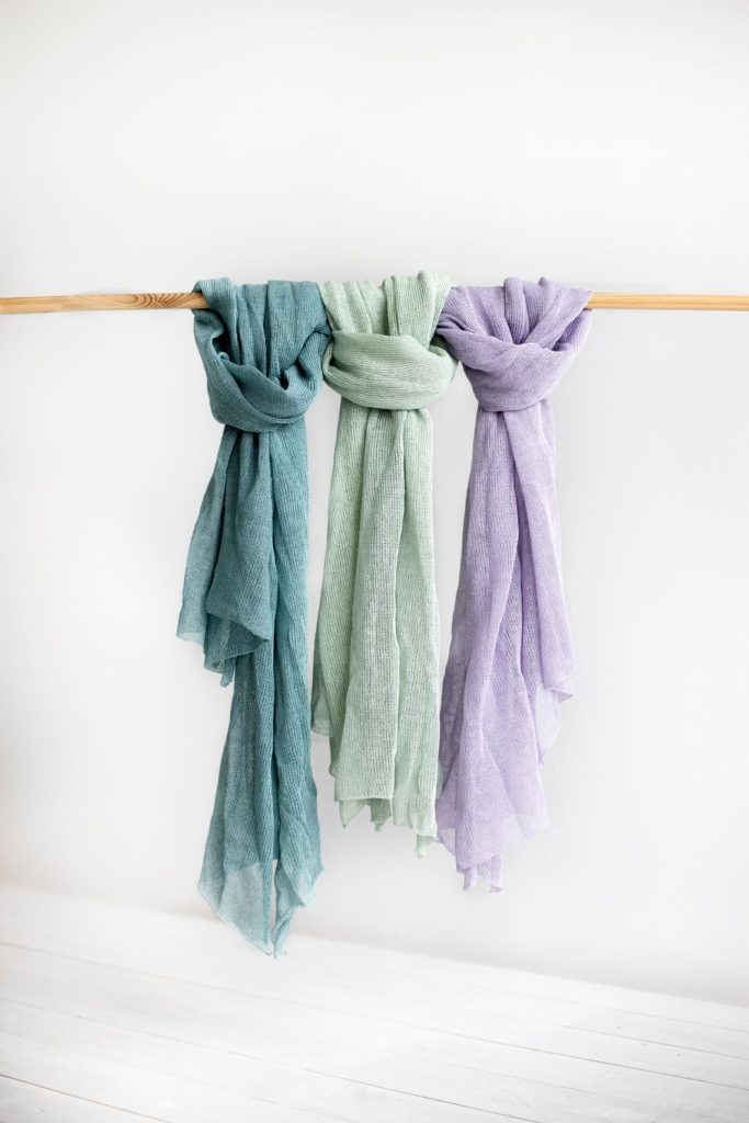 Group of 3 eco-friendly pastel linen scarfs hanging from wood rod