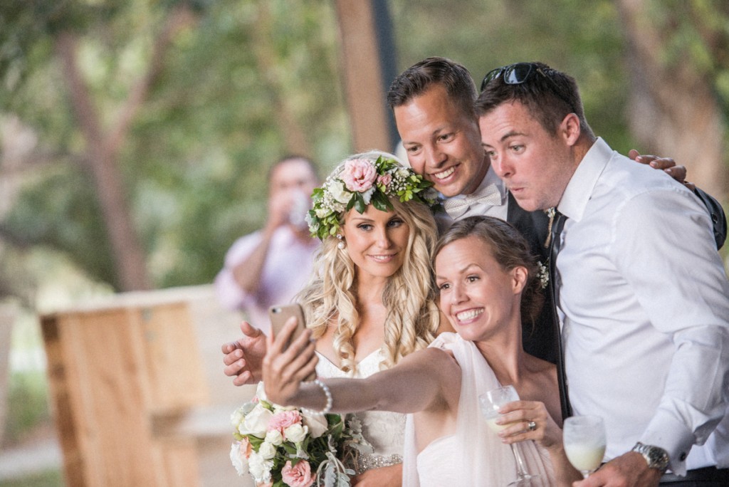 Wedding guest taking a selfie with bride and groom