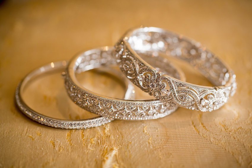 Photo of intricate gold bangles of varying widths for bride