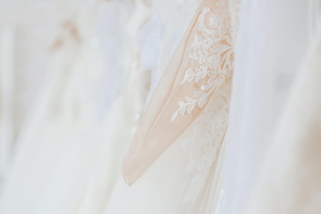 Photo of wedding dress hanging on rack in boutique