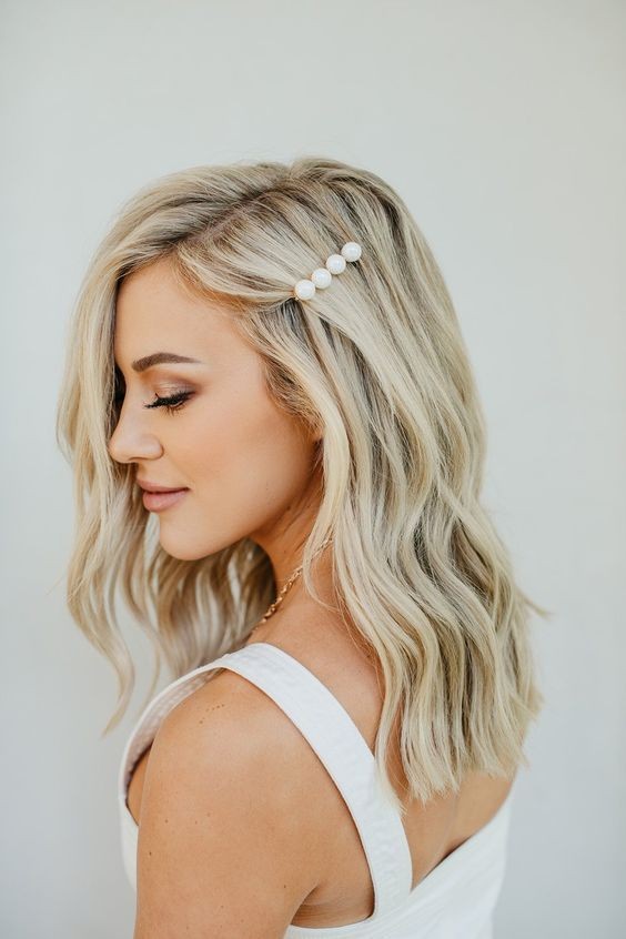 Side view of simple and elegant bridesmaid hairstyle with soft waves and pearl barrette