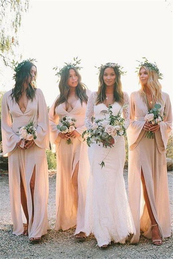 boho bridesmaids wearing soft pink long sleeve dress pose for picture with bride outdoors.