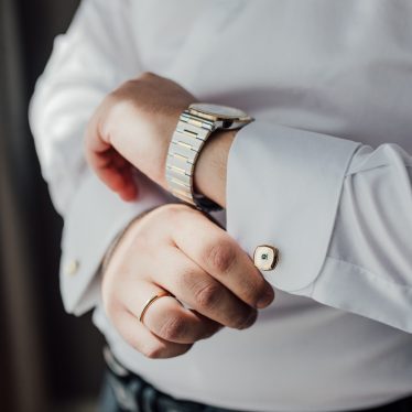 Man wearing wedding ring and adjusting cuff