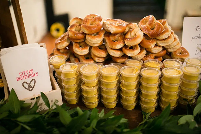 A stack of pretzels with containers of mustard